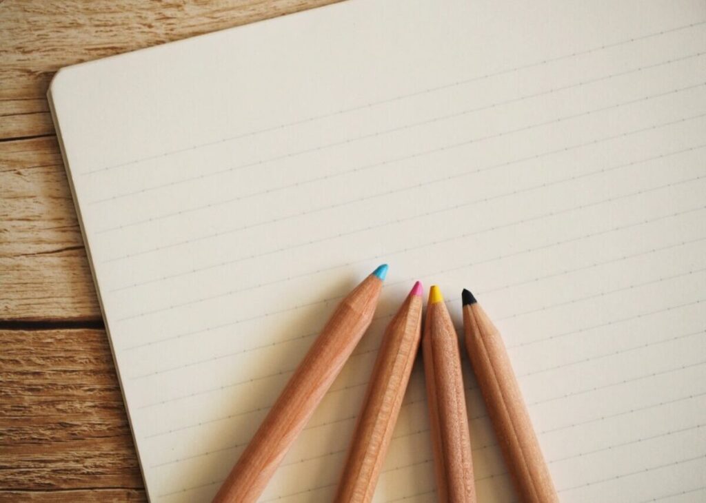 色鉛筆とノートの画像